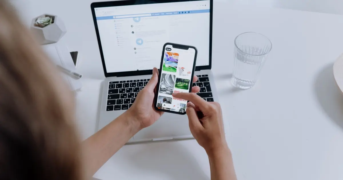 Person using a smartphone beside a laptop connected for mobile work